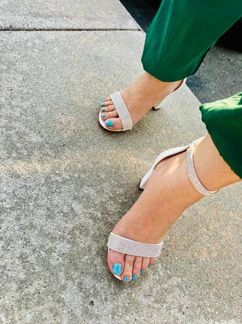 Person wearing open-toed, heeled sandals paired with green pants