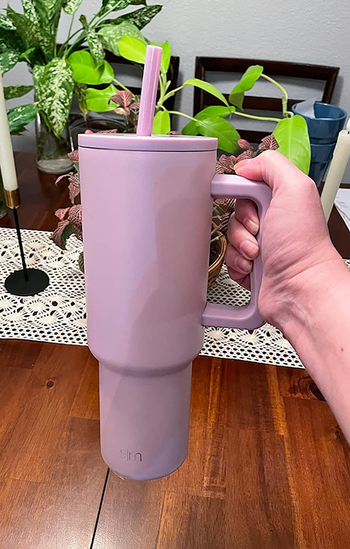a reviewer holding up the simple modern tumbler 
