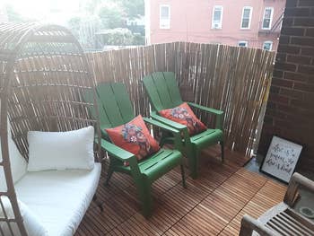 Outdoor patio with greenish Adirondack chairs, floral pillows, a wicker lounge seat, and a framed motion speechmaking