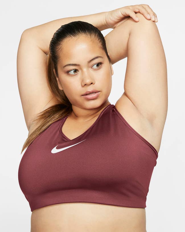 model wears berry-tone Nike medium-support sports bra