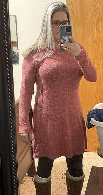 a reviewer wearing the knit dress in pink over leggings 