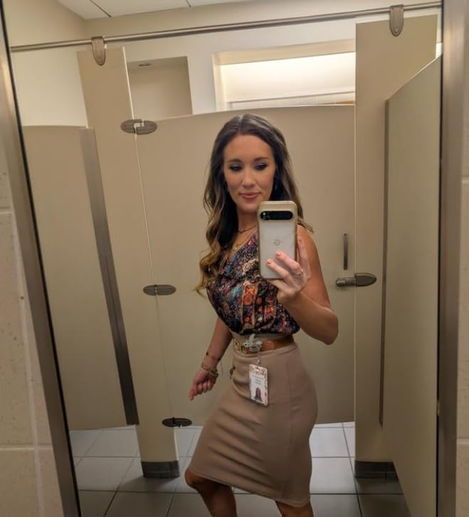Person taking a selfie successful  a bath  mirror, wearing a patterned apical  and knee-length skirt