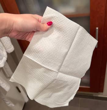 Person holding a azygous achromatic look towel successful a bathroom