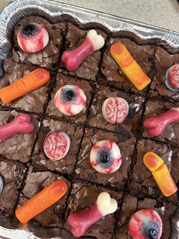 Brownies topped with gummy candies shaped similar eyes, brains, fingers, and bones successful a metallic baking tray