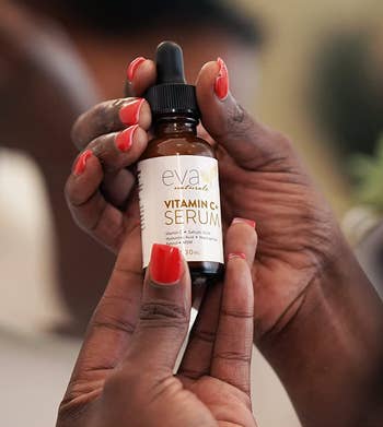 a model holding the bottle of vitamin c serum