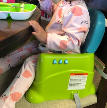 close up of reviewer's child sitting in the booster seat without the attachable tray