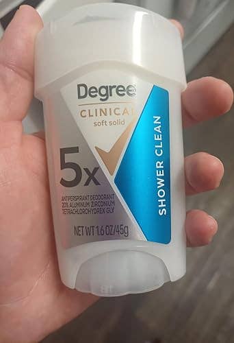 Hand holding a Degree Clinical Protection deodorant stick labeled 