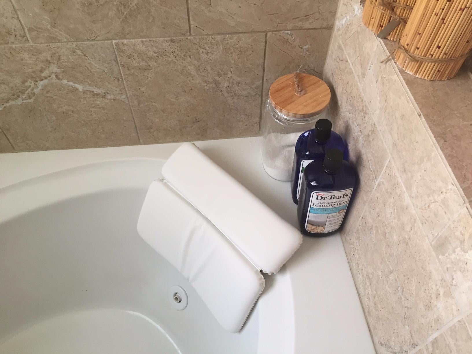 reviewer image of the bath pillow attached to a bathtub