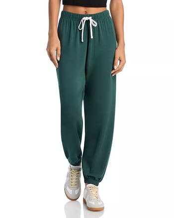 Person wearing greenish  jogger pants and sneakers, highlighting casual and comfy  style, suitable for a relaxed buying  theme