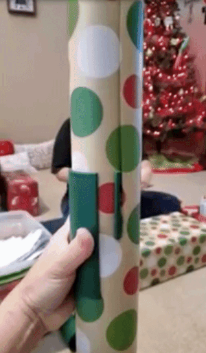 a gif of someone using a wrapping paper cutting tool