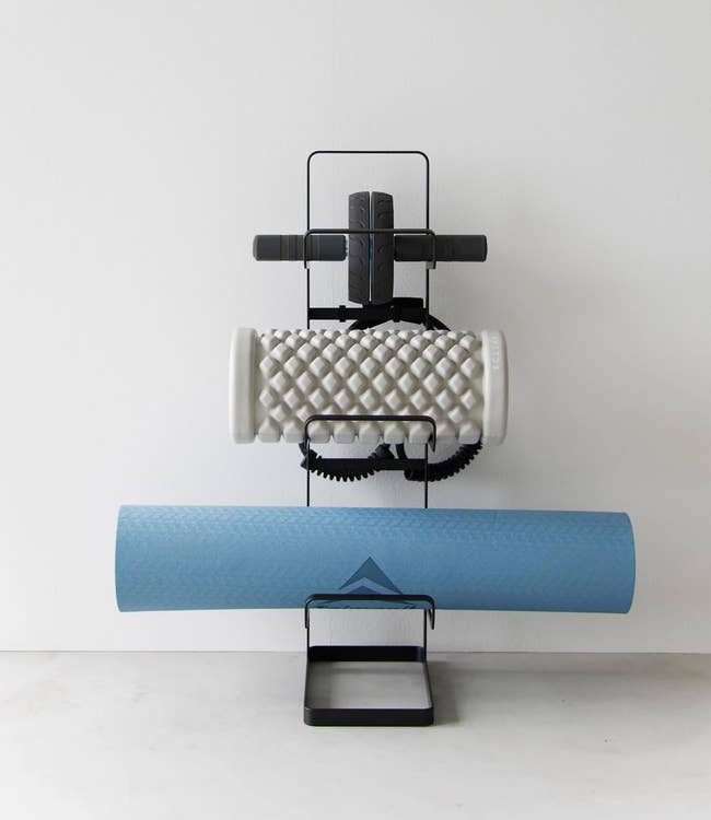 Foam roller and yoga mat neatly organized connected  a minimalist stand, showcasing tidy workout cogwheel  storage