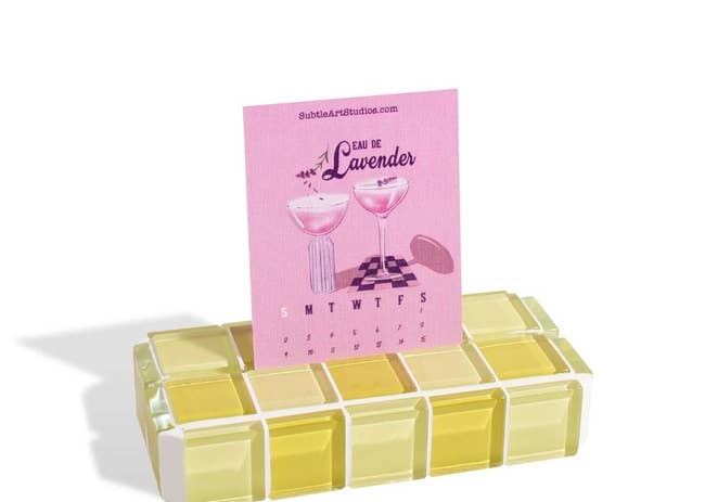 A pink calendar card inserted into the yellow tile picture stand