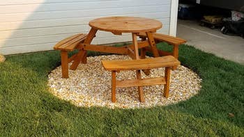 reviewer photo of wooden circular picnic set in backyard