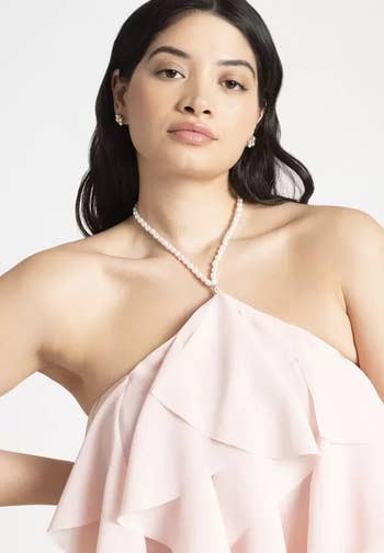 model in elegant attire with a pearl neckline and ruffled detail