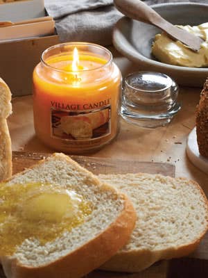 the lit candle next to slices of bread with butter