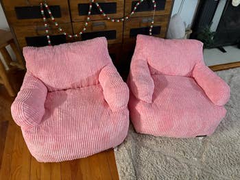 Two pinkish  corduroy armchairs are placed broadside  by broadside  successful  a cozy surviving  country   mounting  with woody  floors and a decorative chest