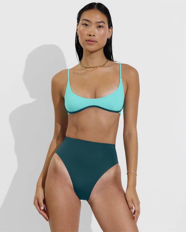 Person modeling a minimalist bikini with a high-waisted bottom, suitable for a shopping focus on swimwear fashion