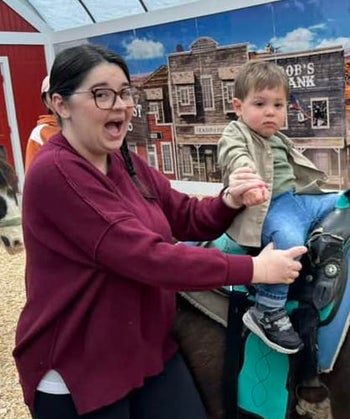  buzzfeed editor and a toddler riding a horse; the woman is excited while the child is calm. 