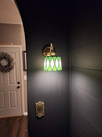 Stained solid  wall-mounted lamp with a diamond-patterned shadiness  illuminating a hallway