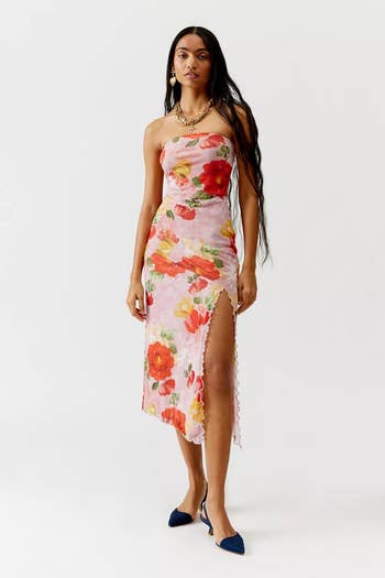 Model in strapless floral dress with slit, paired with blue heels