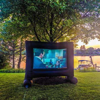 a reviewer's inflatable screen being used by a lake