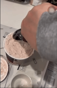 Scooping crystal  pick  from a tub with a grey  crystal  pick  scooper connected  a room  counter