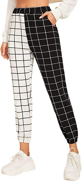 model wearing pants with half black on white grid pattern and half opposite in color