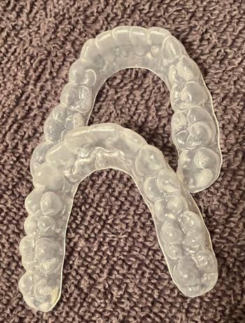 Clear dental retainers placed on a textured surface