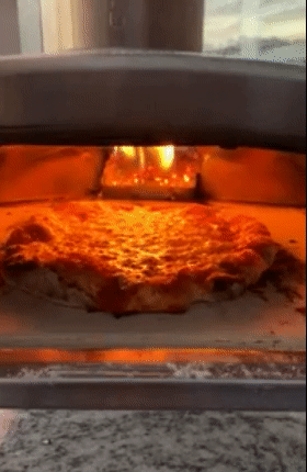 A gif of a pizza being cooked in the oven