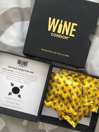 a reviewer photo of the gift box filled with individually wrapped. wine condoms 