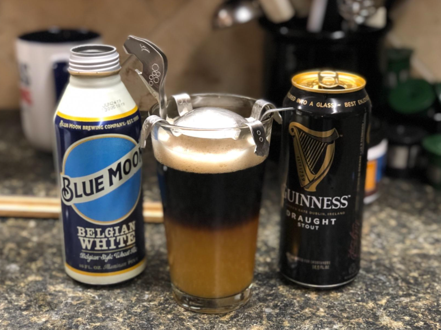 A beer with Blue Moon at the bottom and Guinness stout stacked on top, separated becasue of the turtle device at the top of the glass 
