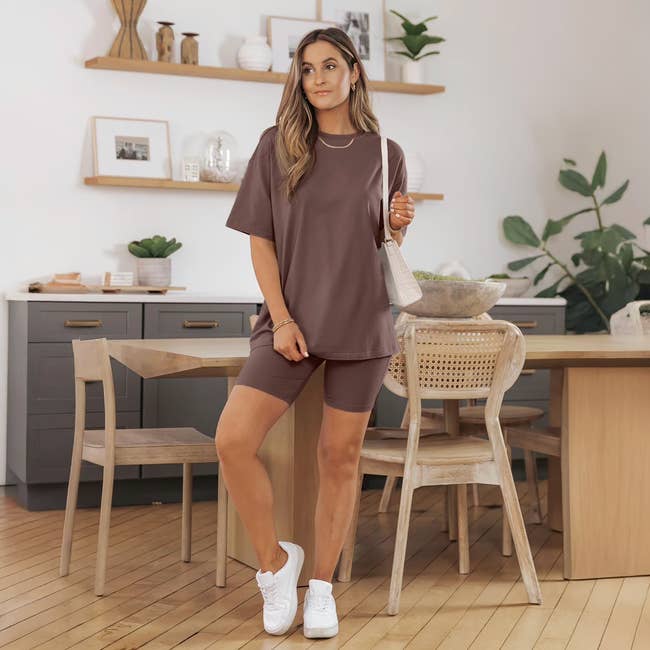Person successful  casual lounge acceptable   with oversized apical  and shorts, lasting  successful  a modern   eating  country  with plants and minimalist decor