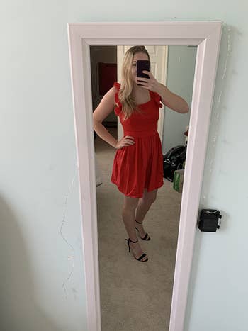 Reviewer is wearing a bold red fit and flare dress