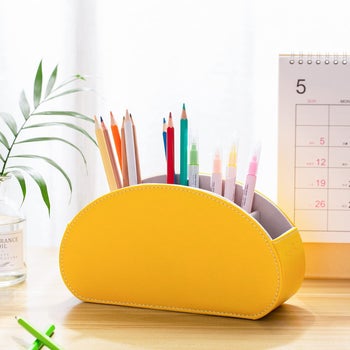 a yellow faux leather pencil cup on a desk