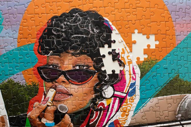 Puzzle featuring a retro-styled illustration of a pistillate with curly hair, wearing sunglasses and a scarf, applying lipstick