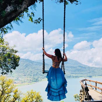 reviewer on a swing showing strappy back of blue dress