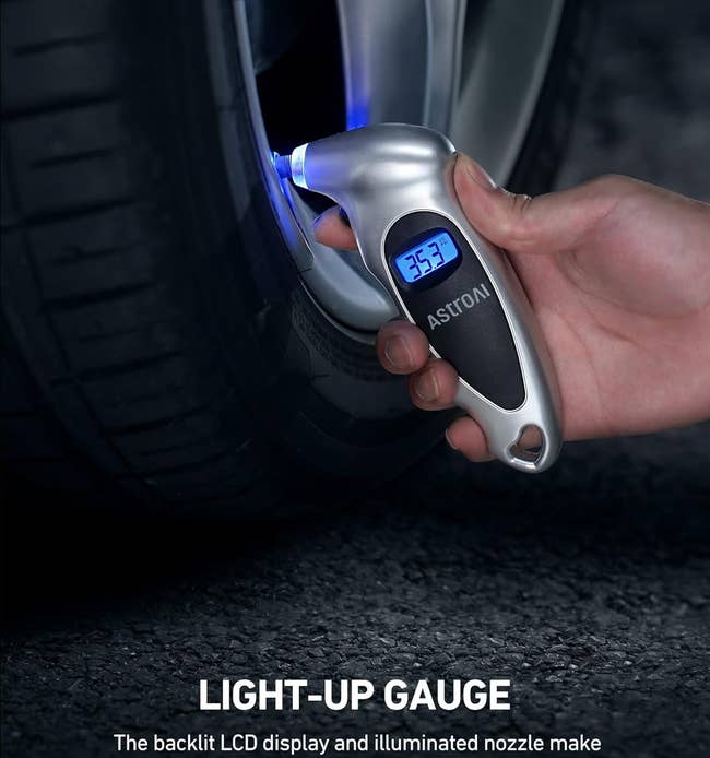 model's hand using the digital light-up pressure gauge on a tire