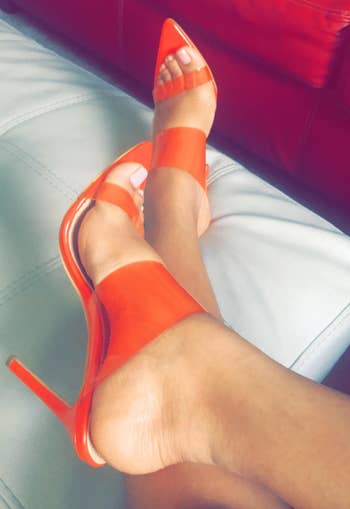 reviewer wearing transparent bright orange heels
