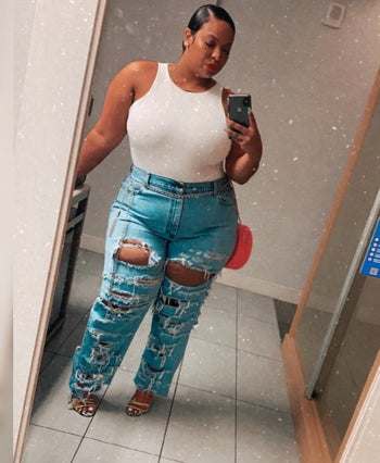 reviewer wearing the white bodysuit with ripped jeans and heels