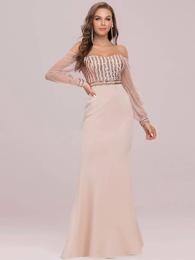 Model wearing rose gold sequined dress with sheer cold-shoulder sleeves
