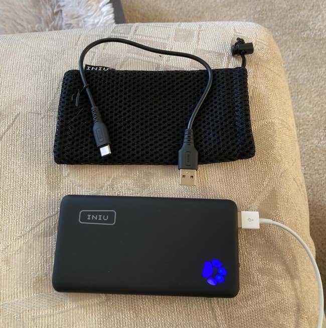 power bank with charging cord attached and mesh bag with another cord on it
