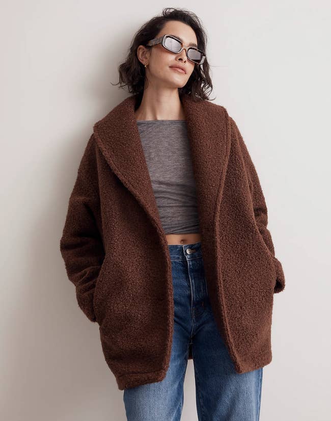 a model wearing a faux shearling shawl collar coat in brown