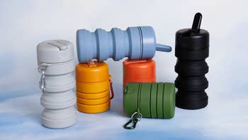 Various collapsible, reusable water bottles are displayed in different shapes, sizes, and colors, equipped with carabiner clips for easy attachment