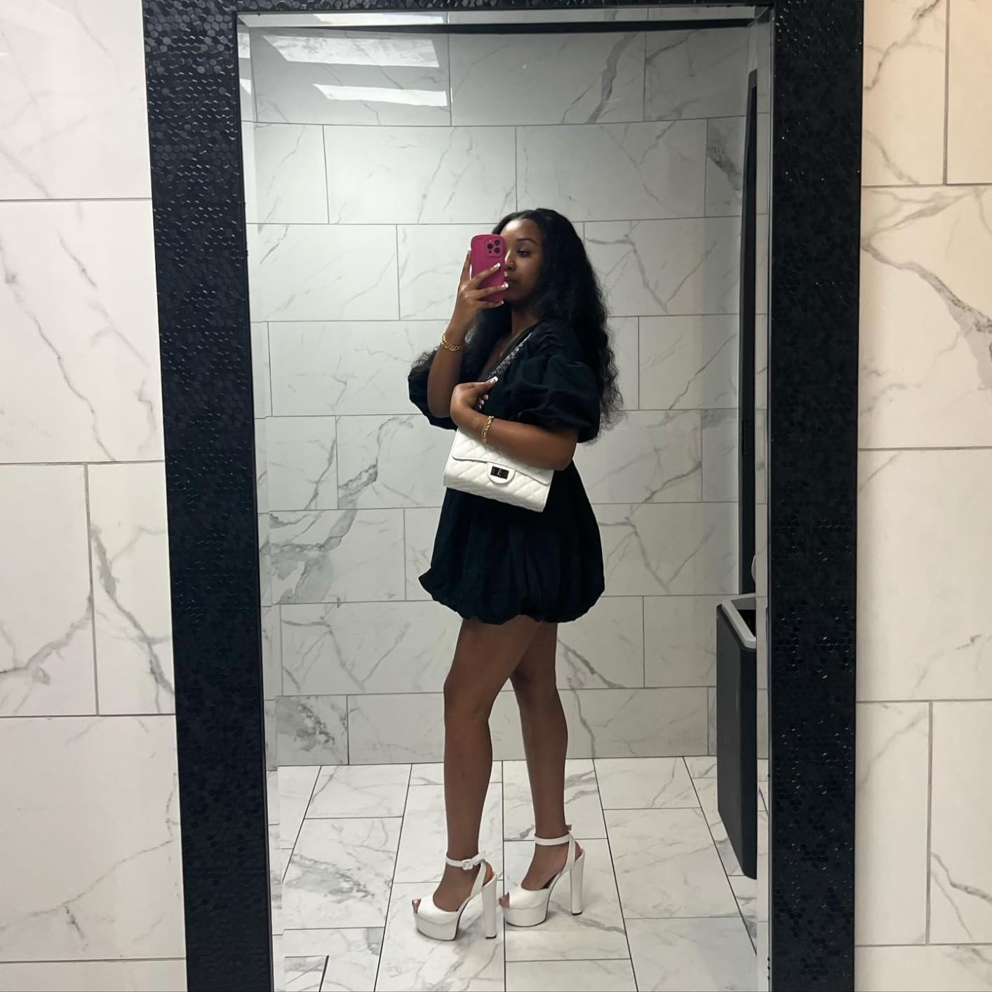 Person wearing a stylish abbreviated  formal  and precocious   heels, holding a achromatic  purse, takes a reflector  selfie. Suitable for a buying  article