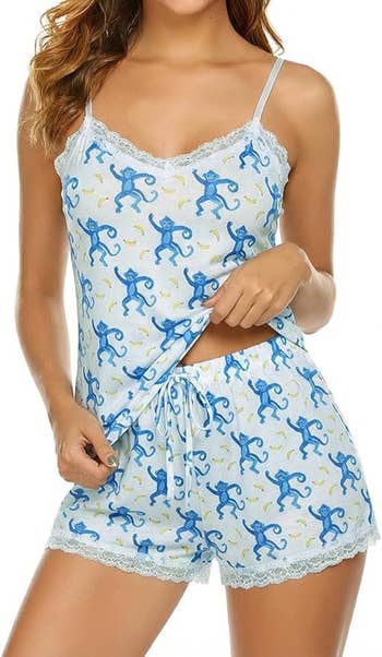 Woman wearing a pajama acceptable   with a bluish  monkey print, featuring a lace-trimmed camisole and shorts