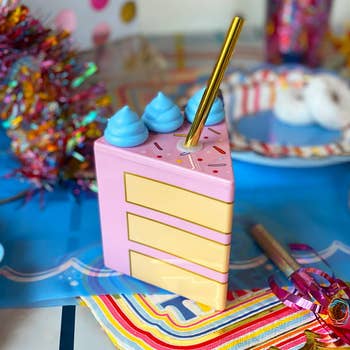 The cake slice cup with gold straw on a table
