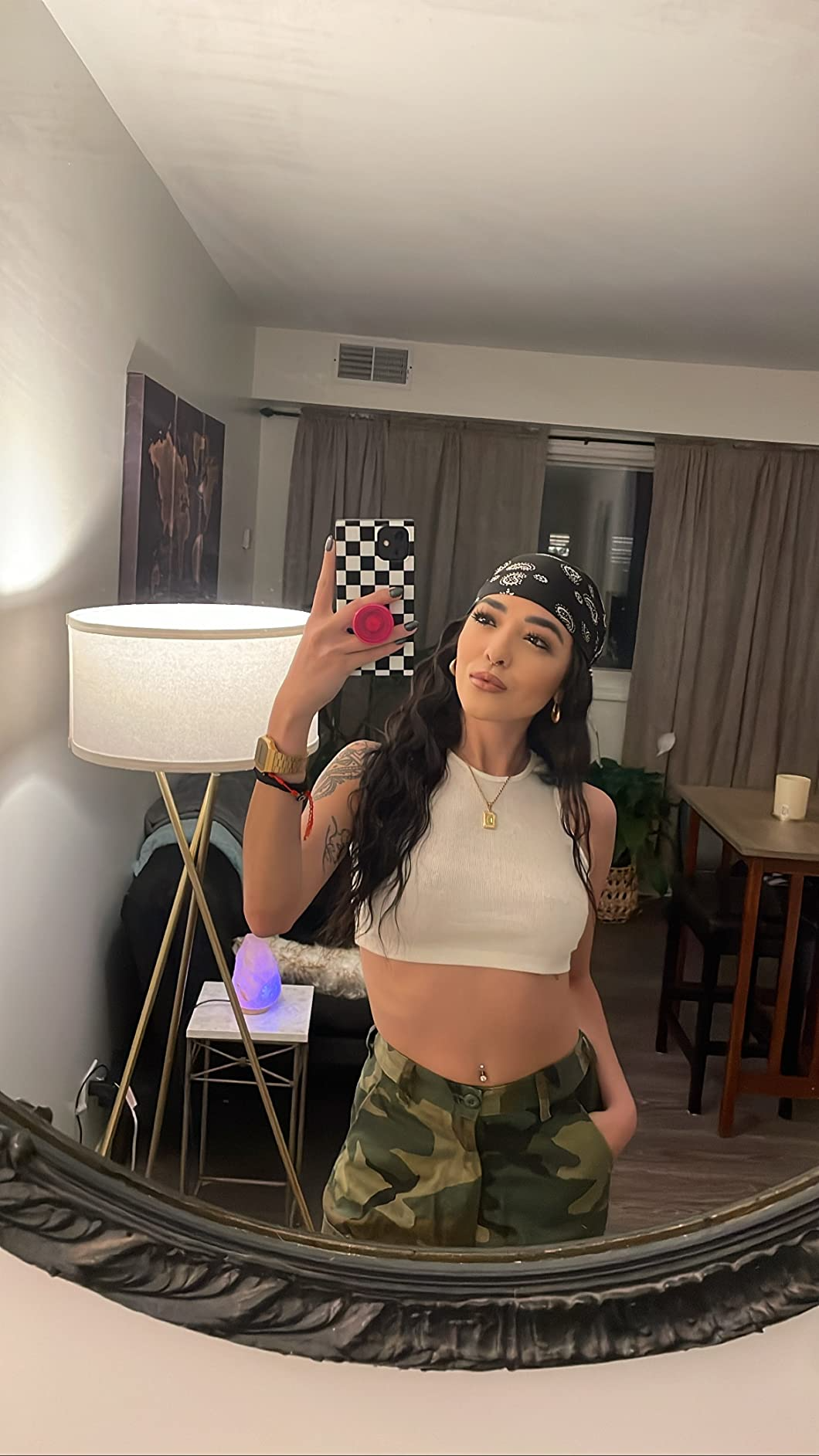 Reviewer successful  a achromatic  harvest  top, camouflage pants, and a headscarf taking a reflector  selfie successful  a modern   surviving  room