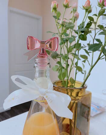 wine bottle with a pink bow stopper on top 