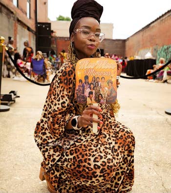 Person kneeling outdoors successful a leopard-print outfit, holding a instrumentality with