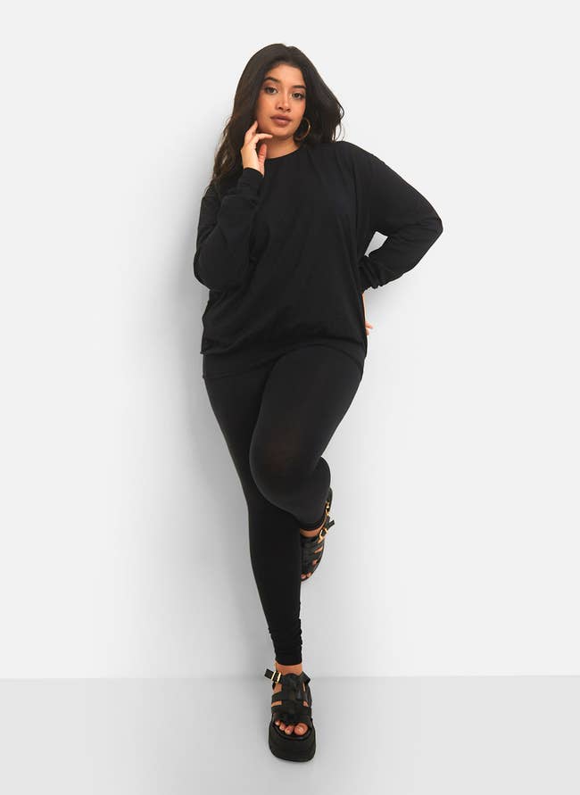 a model in black leggings and black sweatshirt